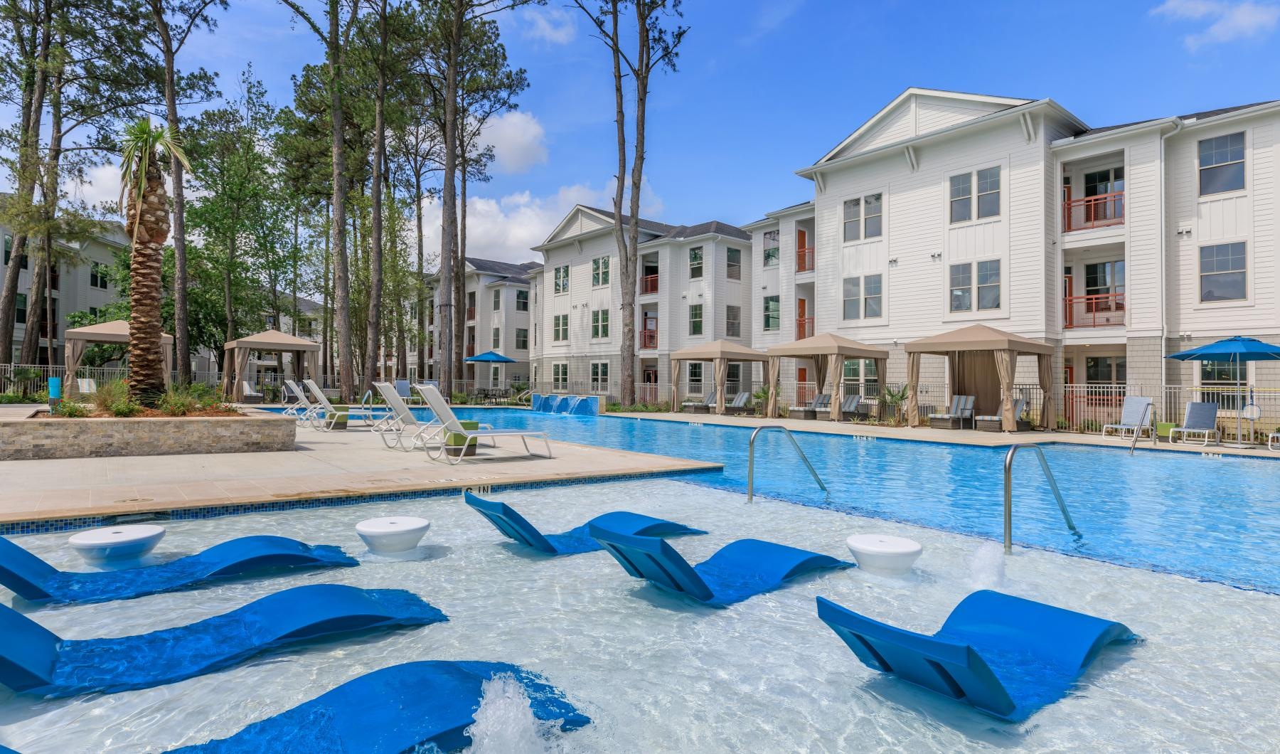 a swimming pool in front of a large white building