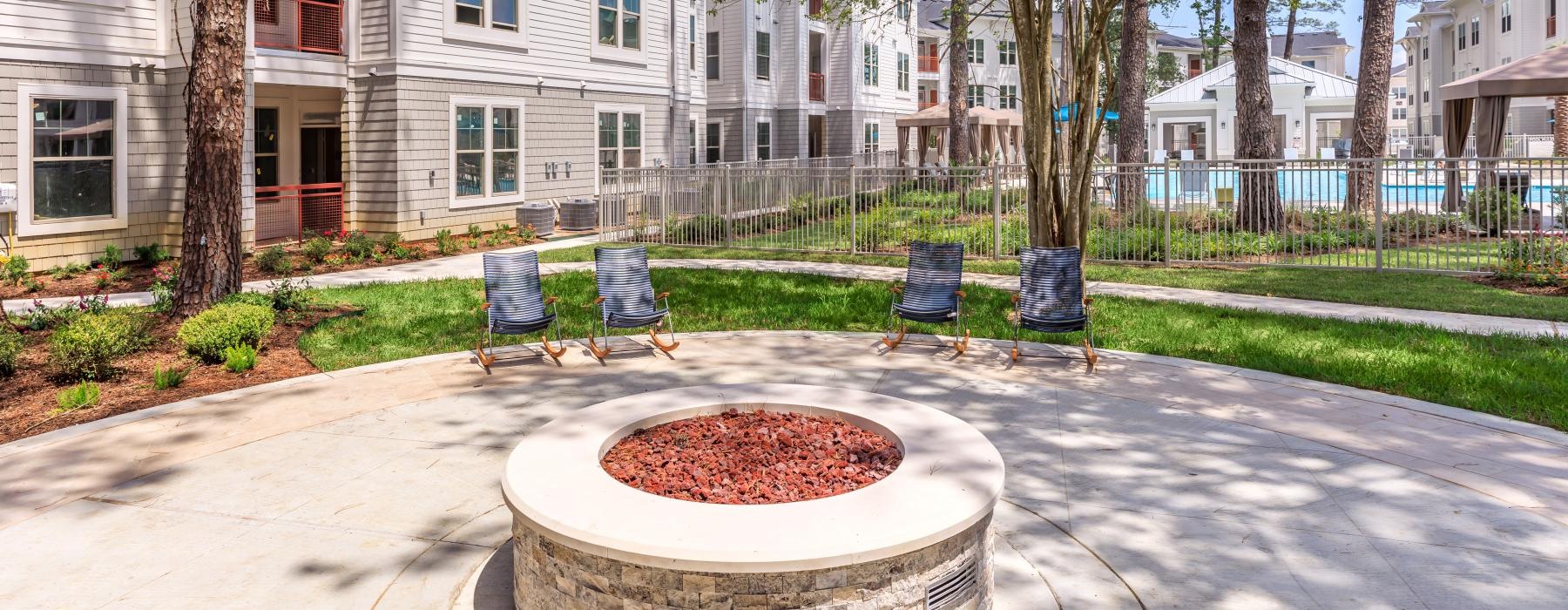 a firepit and chairs in front of a building