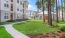 outdoor green area with trees in front a building